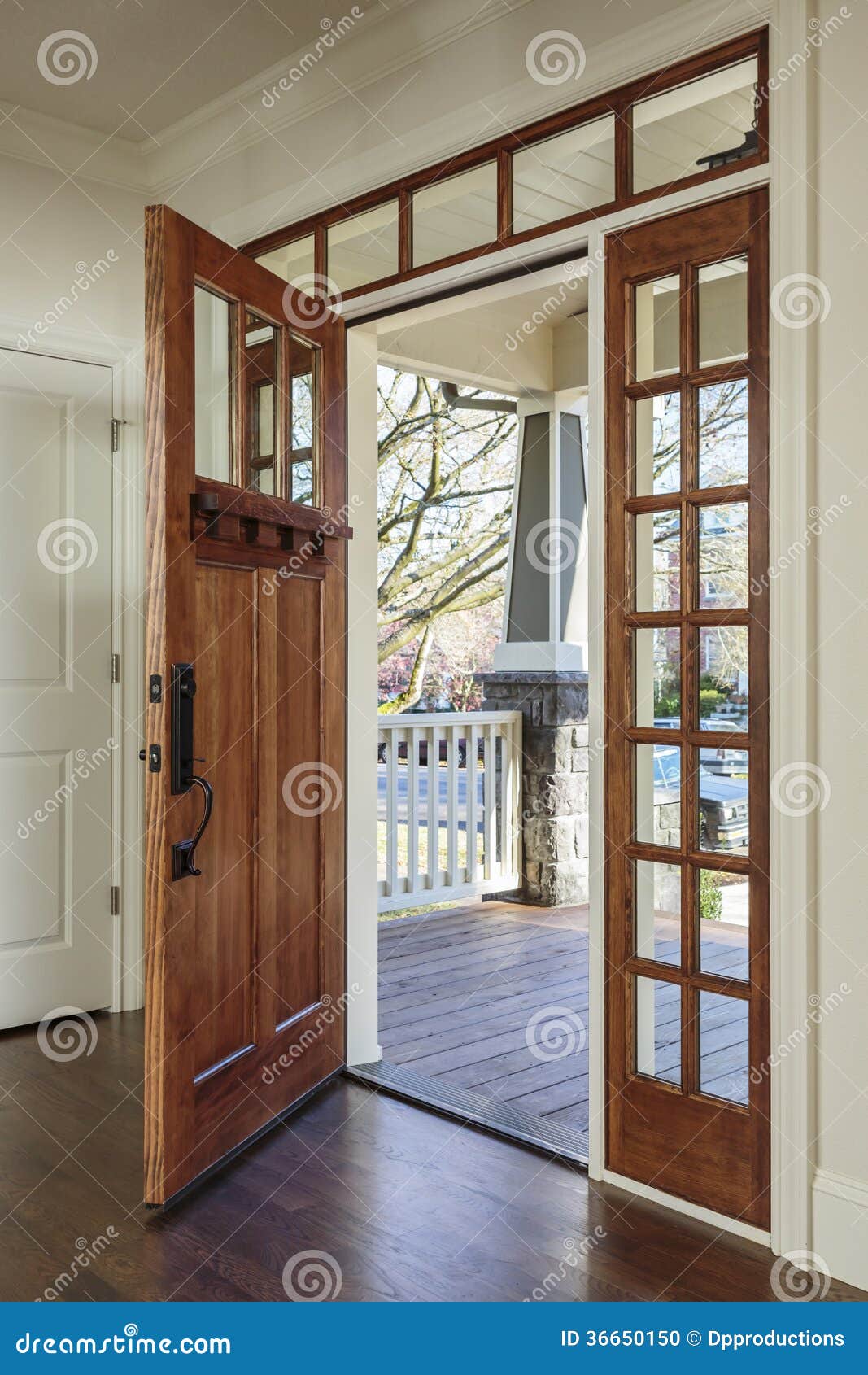 Vertical shot of wooden front door of an upscale home with windows.