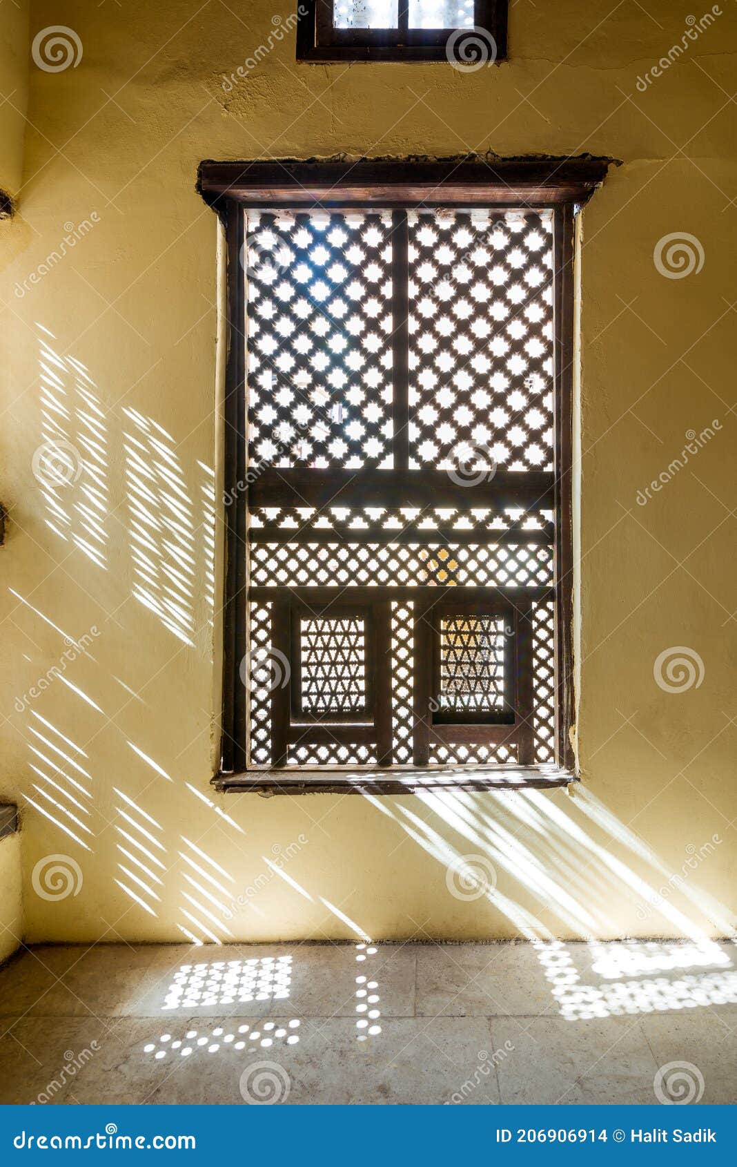 interleaved wooden ornate window - mashrabiya - in stone wall