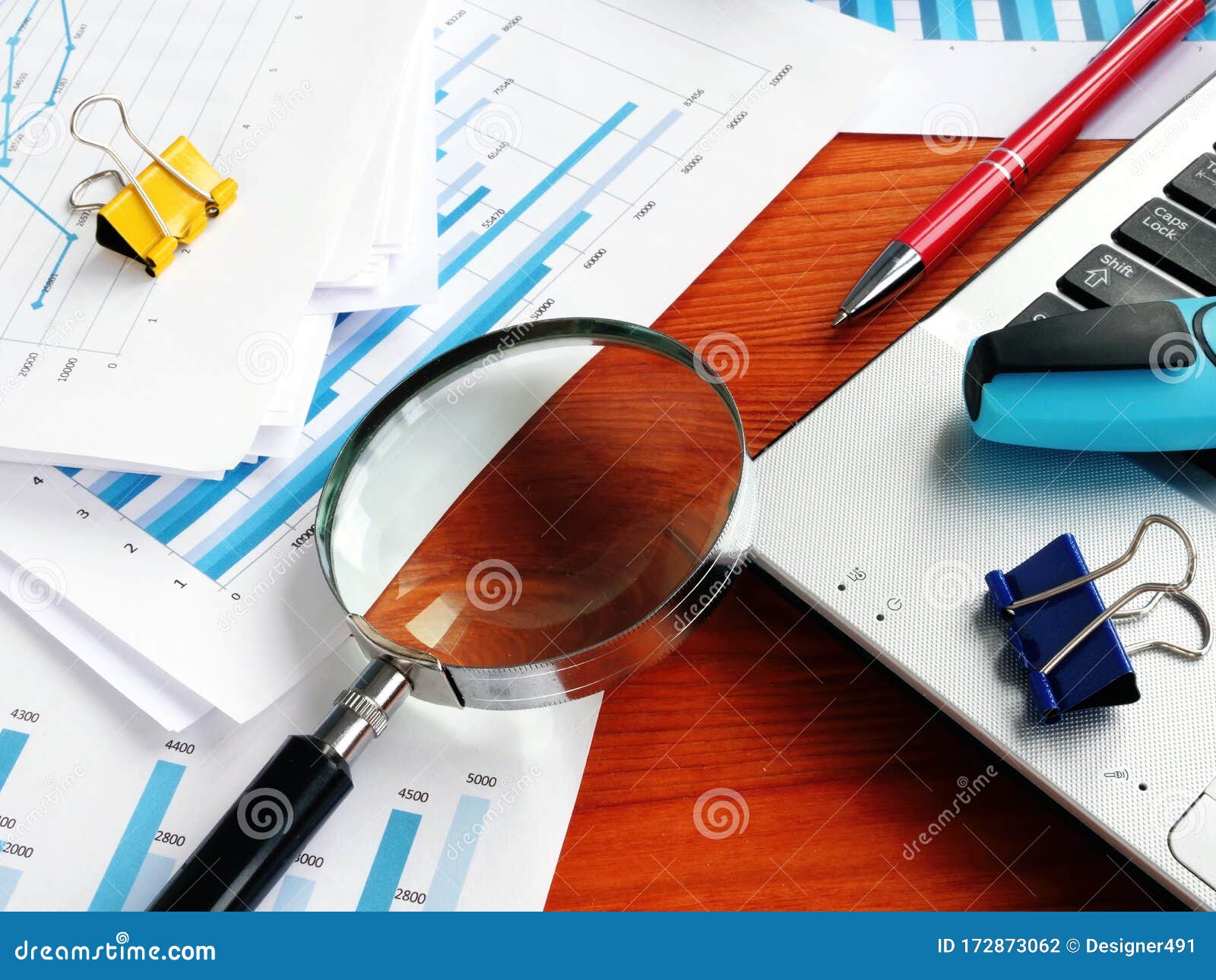 internal business audit. magnifying glass on the pile of financial reports