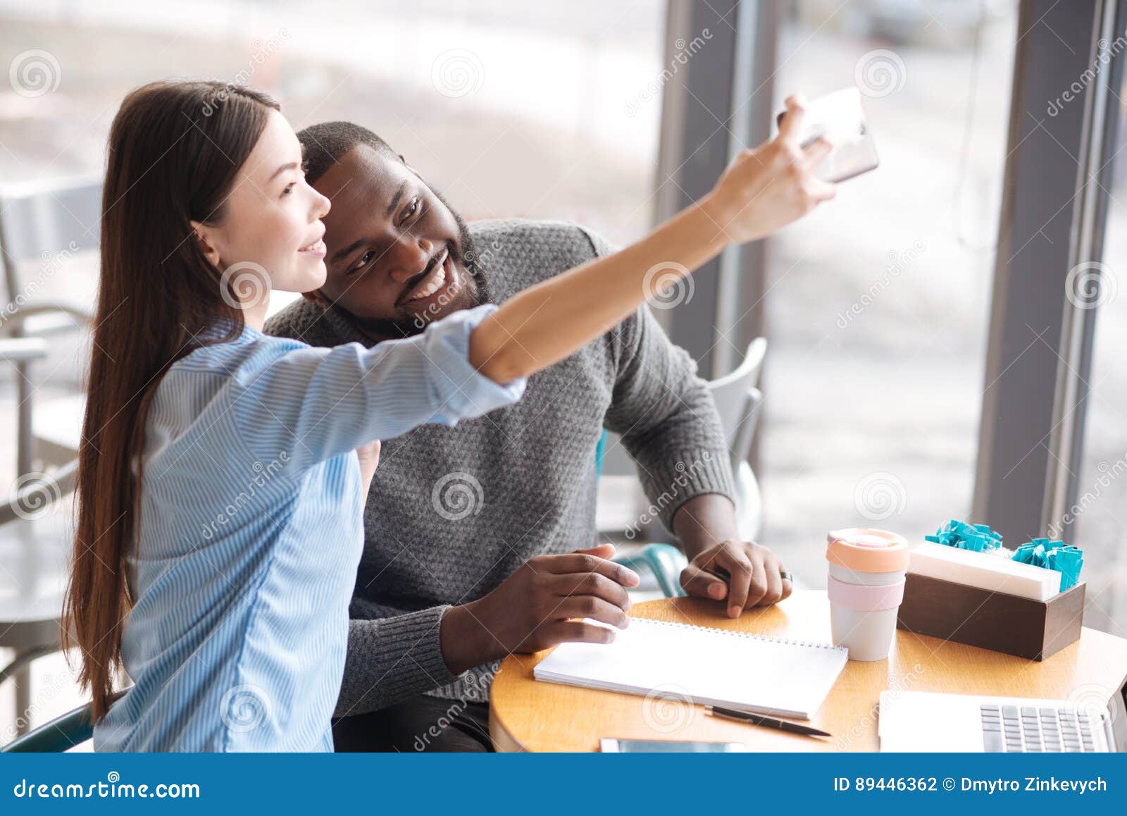 https://thumbs.dreamstime.com/z/international-couple-doing-selfie-lets-post-pretty-young-women-her-male-friend-sitting-near-big-window-89446362.jpg