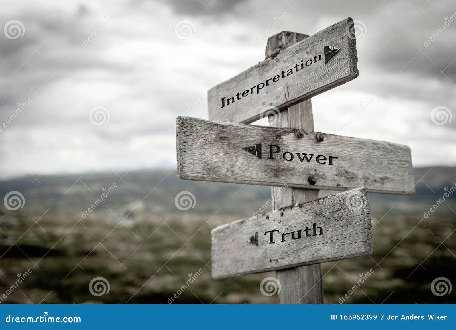 interpretation, power and truth text on wooden rustic signpost outdoors in nature/mountain scenery.