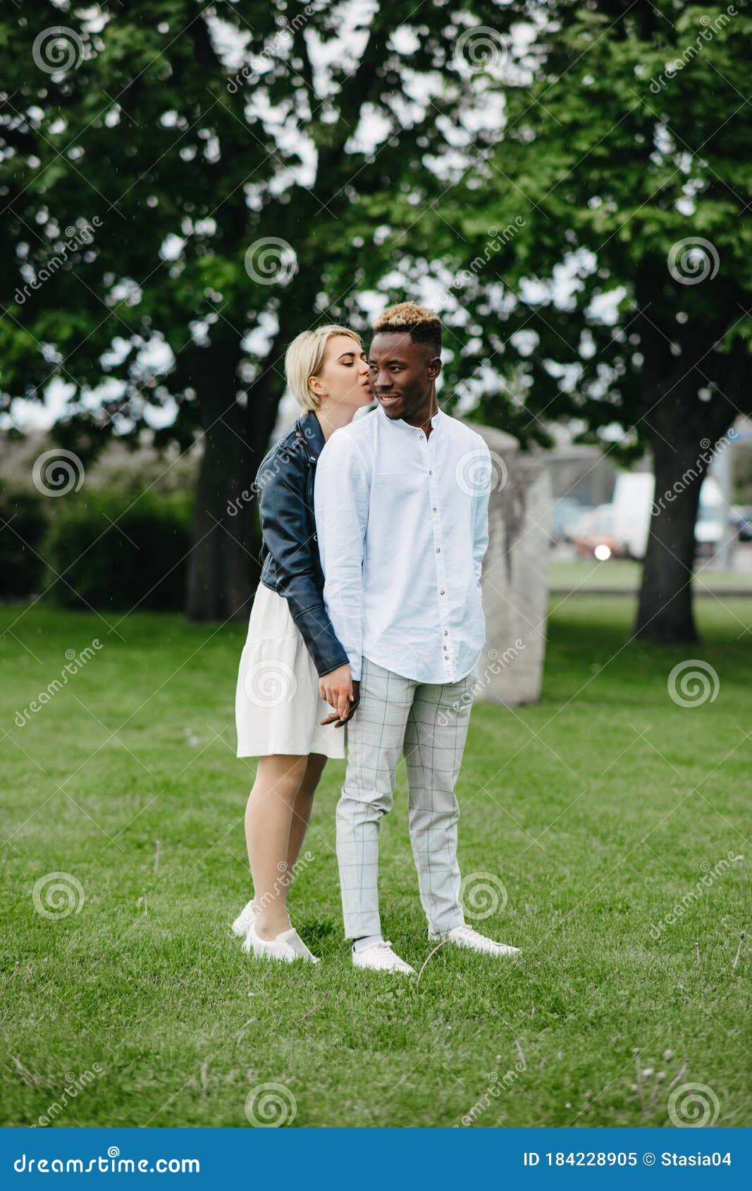 Interracial Couple Holds Hands And Kisses In Park Stock Image Image