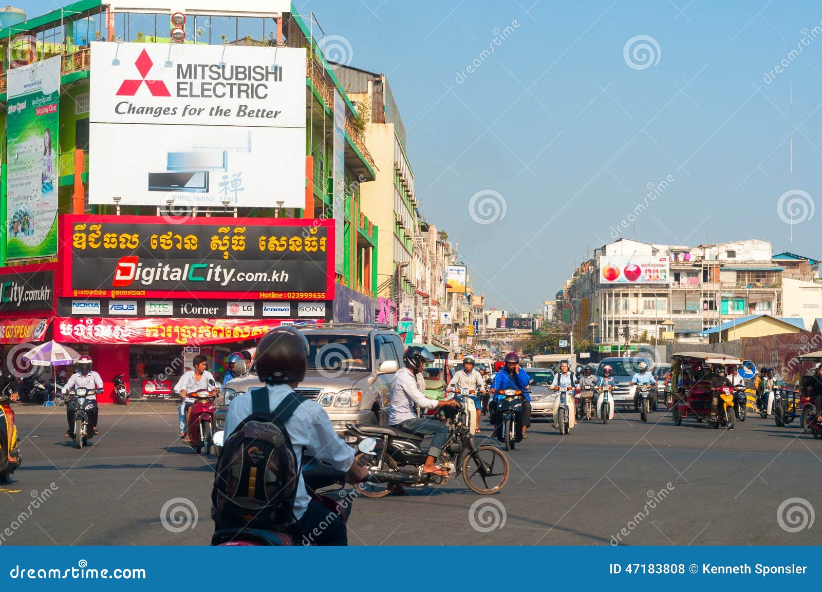 PHNOM PENH, CAMBODGE - 27 FÉVRIER 2014 : Une intersection occupée en capitale cambodgienne a le trafic se déplaçant dans beaucoup de directions sous des signes d'activité économique éclatante