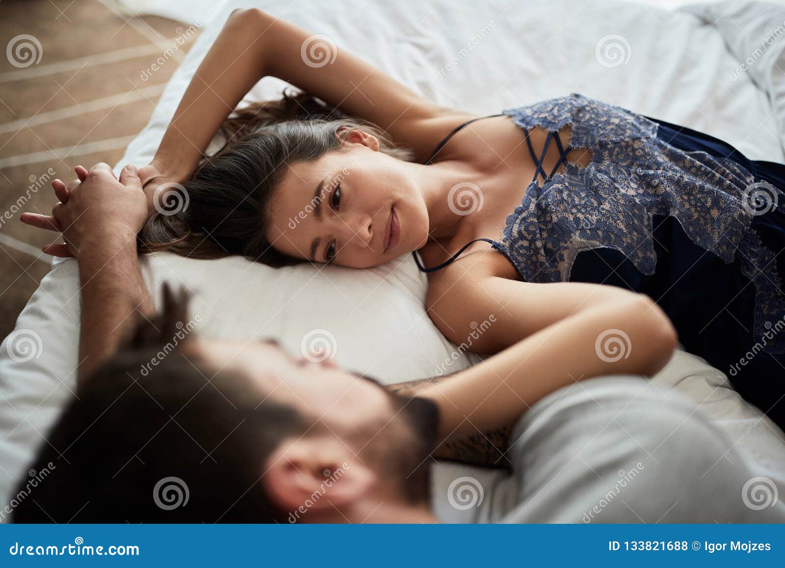 intimate woman and man during foreplay in bed