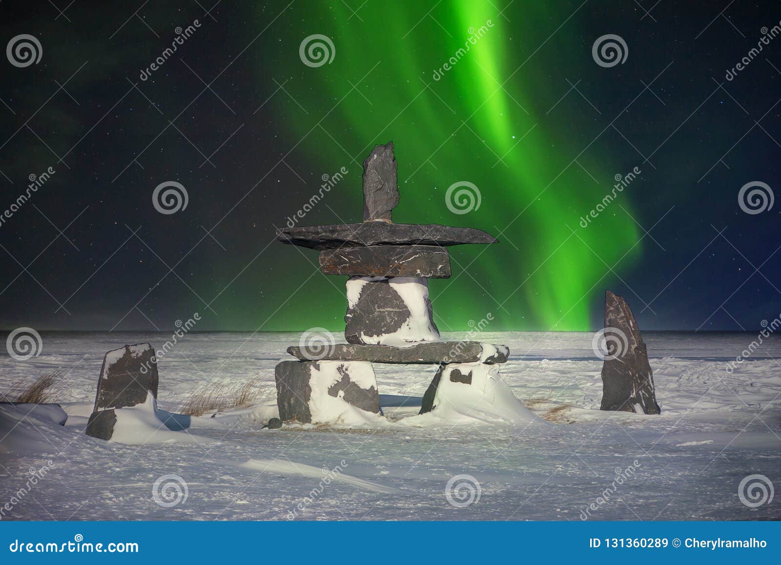 inukshuk and northern lights in canada.