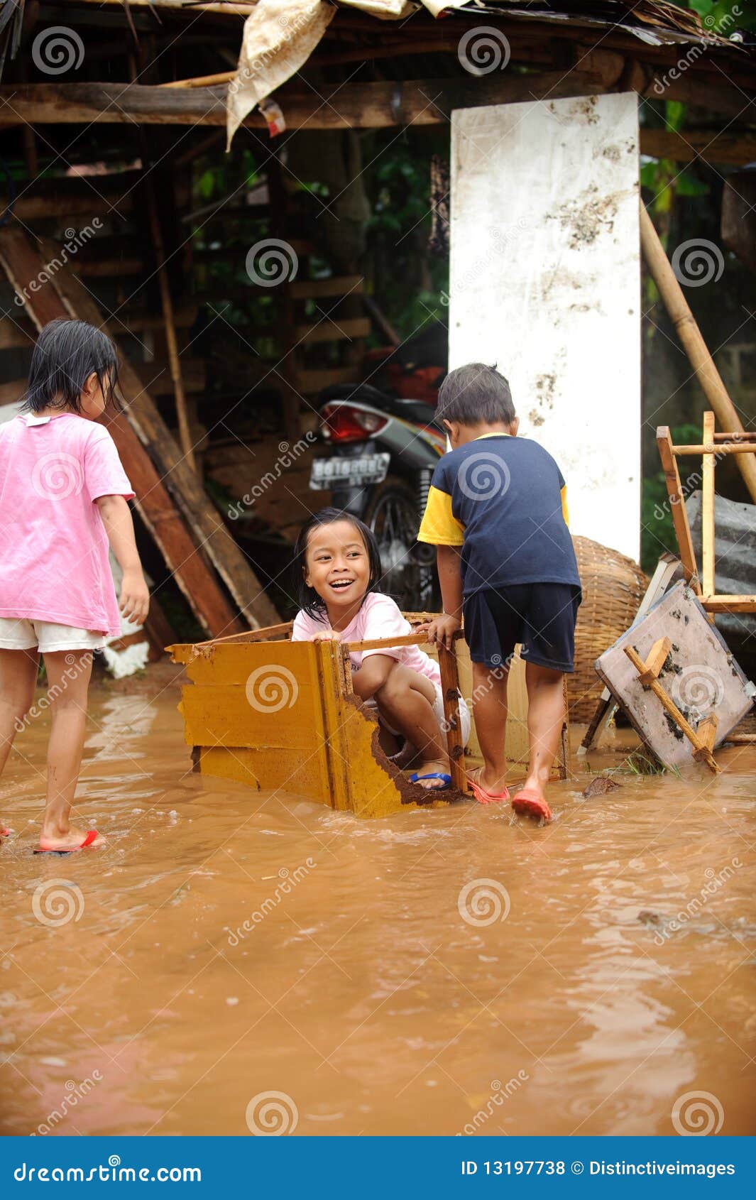 Inundación, el jugar de los niños. Niños que se divierten el jugar durante una inundación