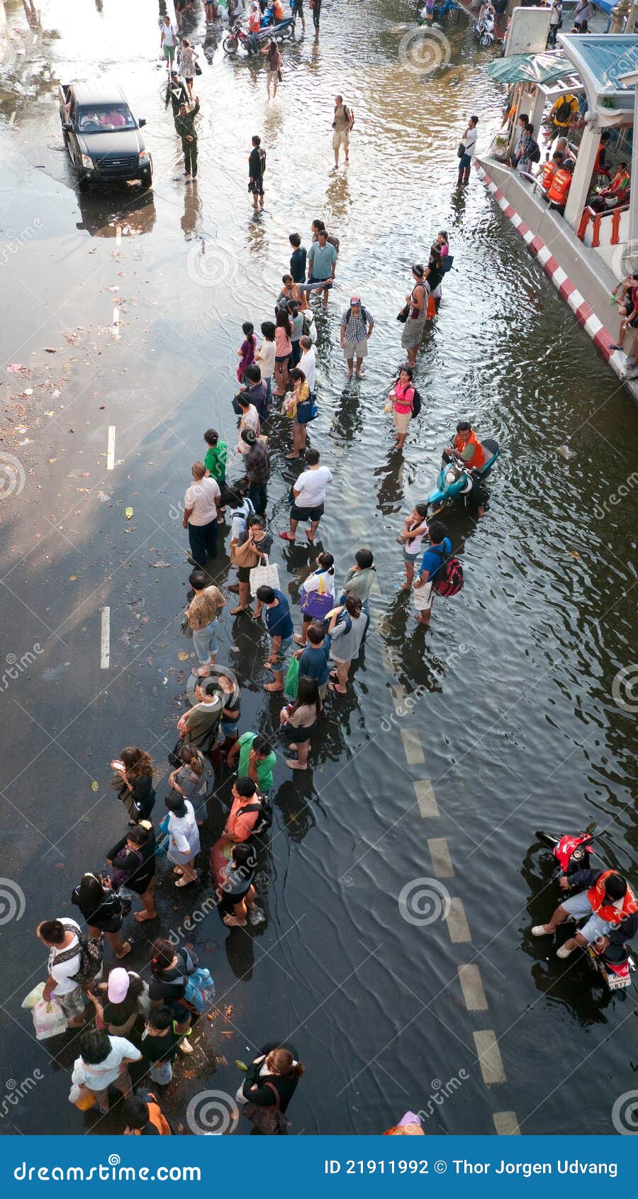 Inundación en Bangkok, noviembre de 2011 de la monzón. BANGKOK, TAILANDIA - 6 DE NOVIEMBRE: Pasajeros del omnibus que esperan el transporte en un área inundada durante la inundación peor de décadas en Bangkok, Tailandia el 6 de noviembre de 2011.