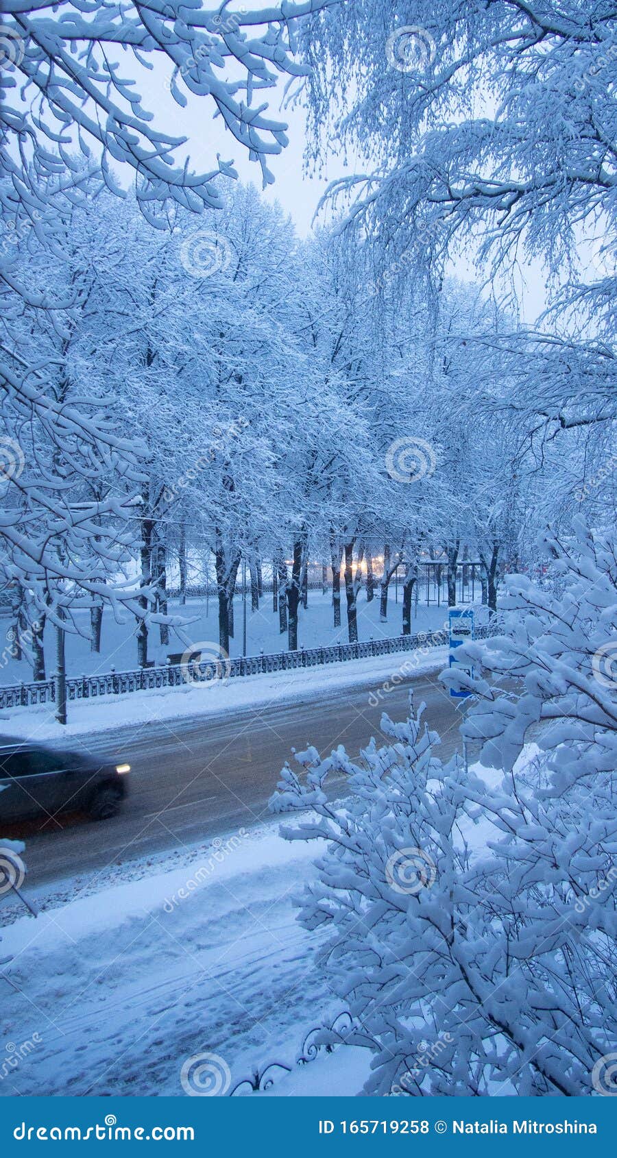 Inverno de neve, rua da cidade, carro na estrada Ver as árvores na neve na estrada