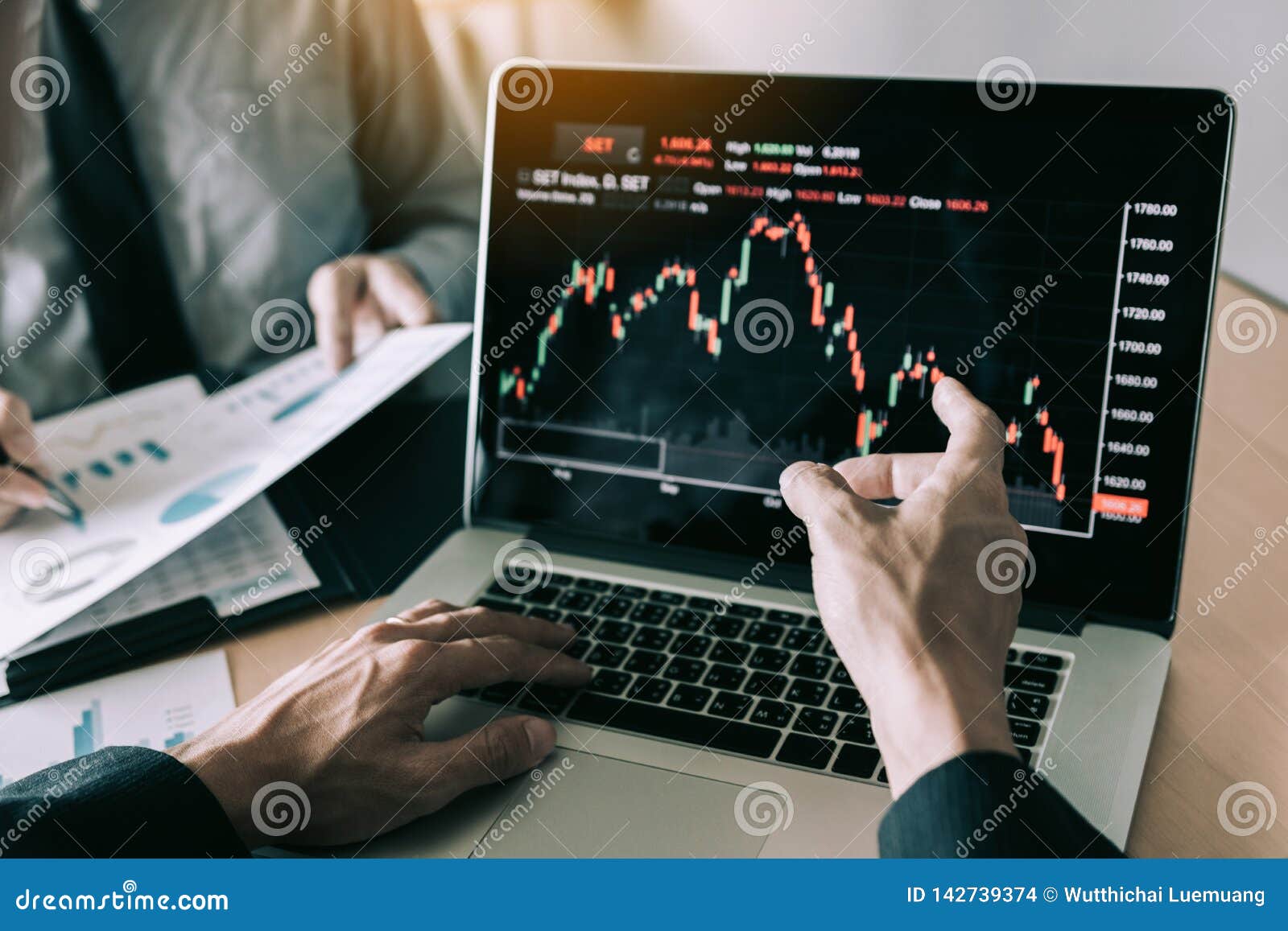 investors are pointing to laptops that have investment information stock markets and partners taking notes and analyzing