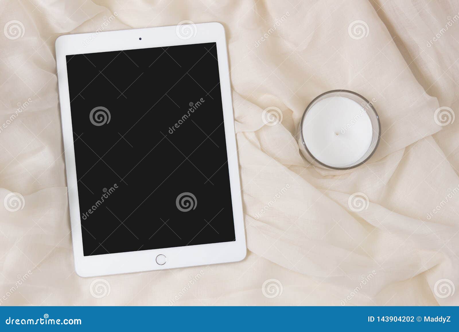 ipad apple tablet with a candle. elegant and cozy feminine background, concept for advertisement