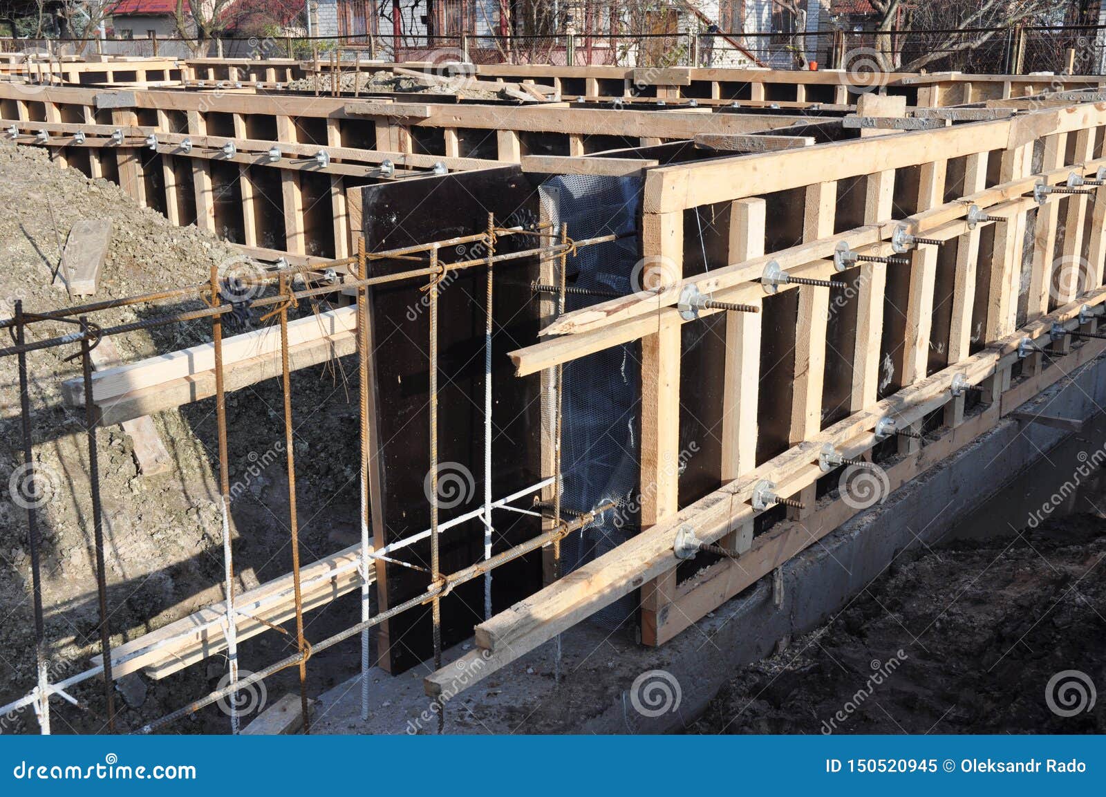 iron and wooden framework to build a house foundation uder construction. incomplete house foundation construction site