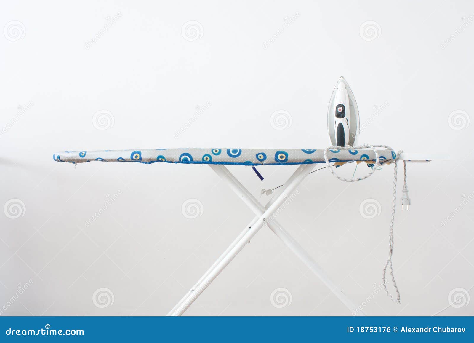 On The Ironing Board Is A Blue Iron And Neatly Folded Ironed Stack Of