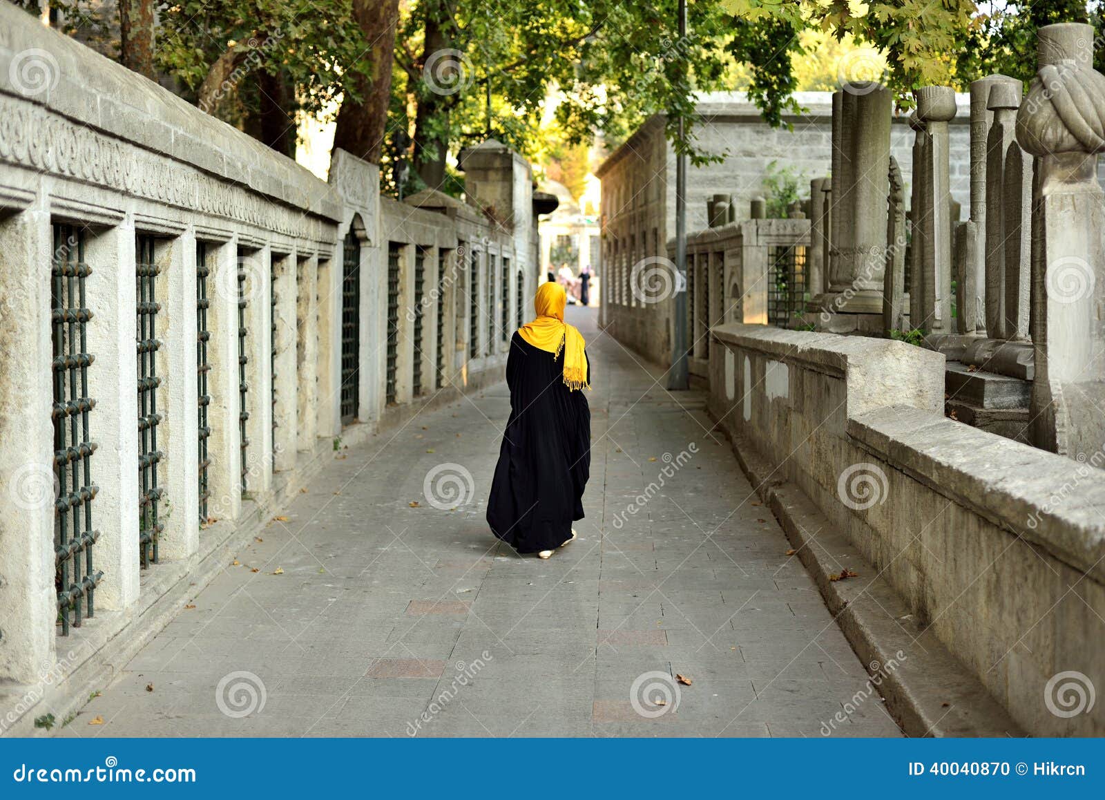 islamic old gravestone in a cemetery and women