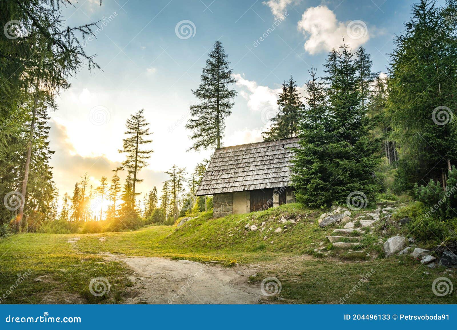  cabin in mountains surrounded by deep forrest, sunset in background with sunrays. slovakia tatra mountains