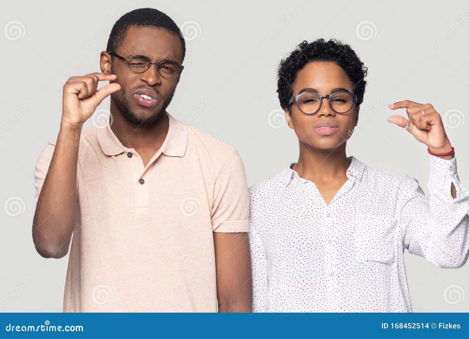 african couple showing with fingers something small studio shot