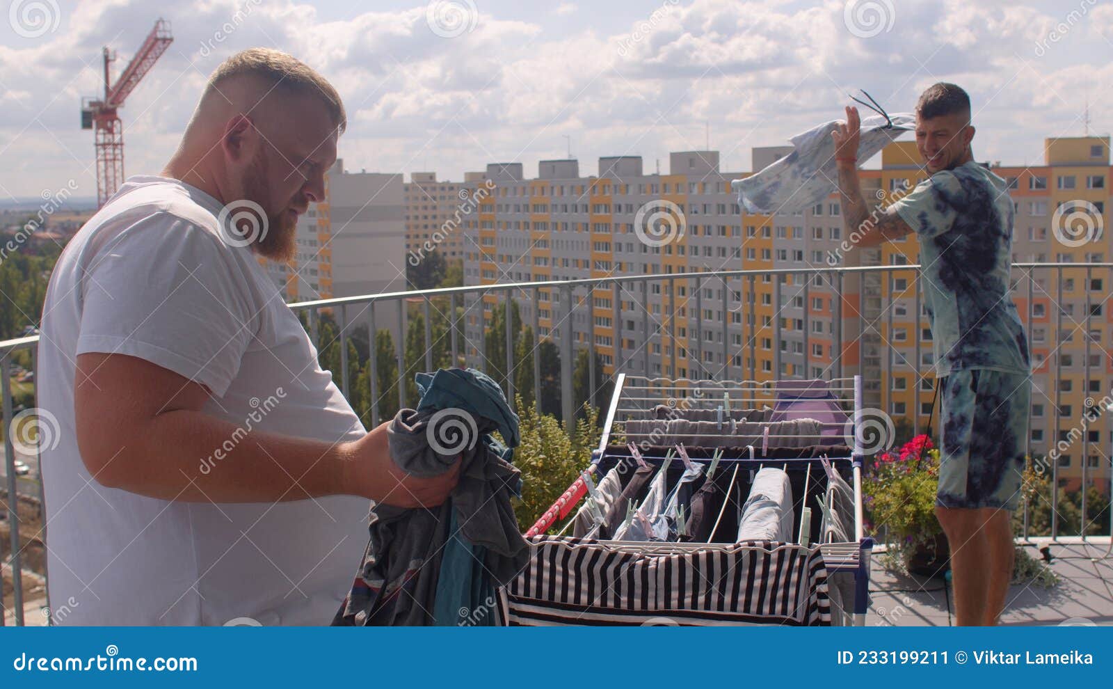 A Gay Couple Hangs Up the Laundry on the Balcony To Dry Stock Image