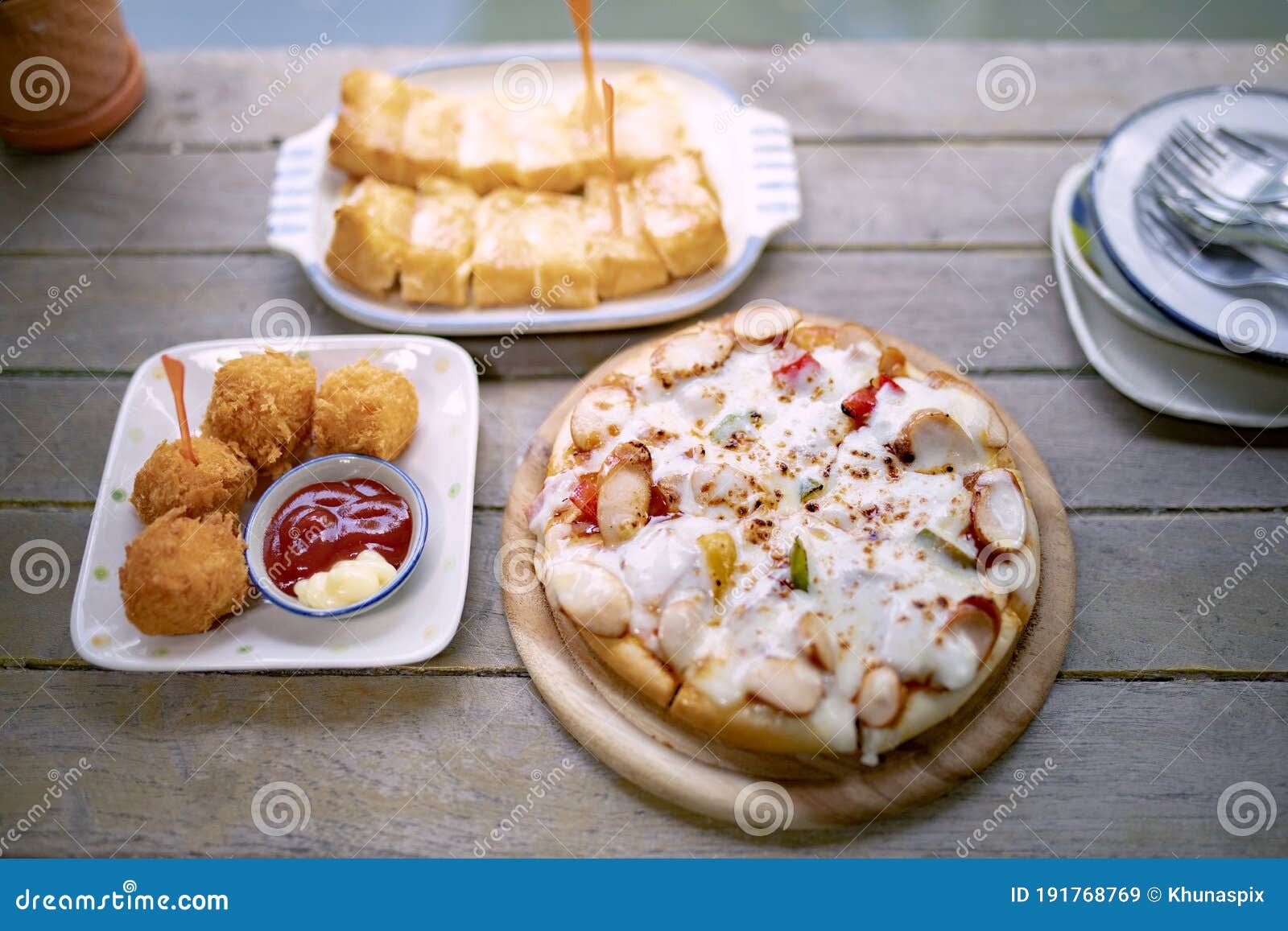 italain pizza ,chicken ball and bread butter sungar on top read to eaton wood table