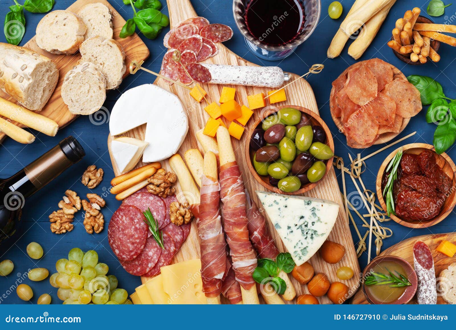 italian appetizers or antipasto set with gourmet food on kitchen table top view. mixed delicatessen of cheese and meat snacks