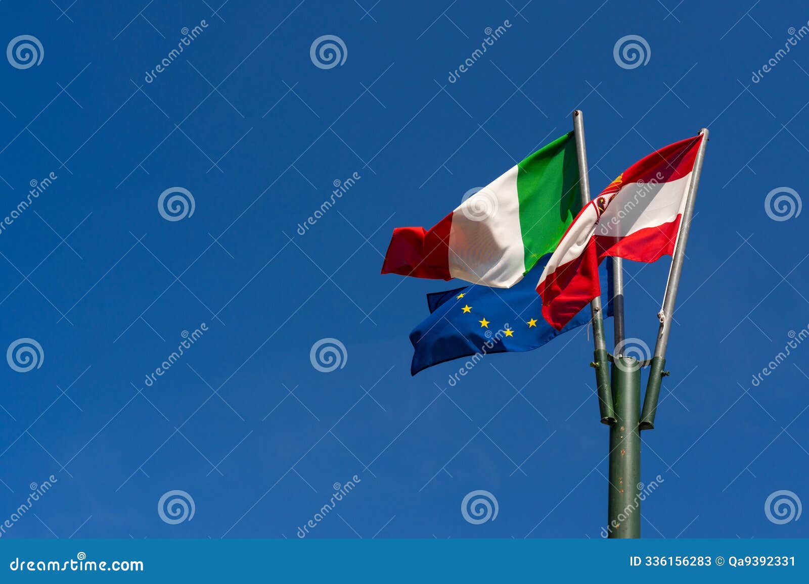 italian austrian and eu flags waving in clear sky