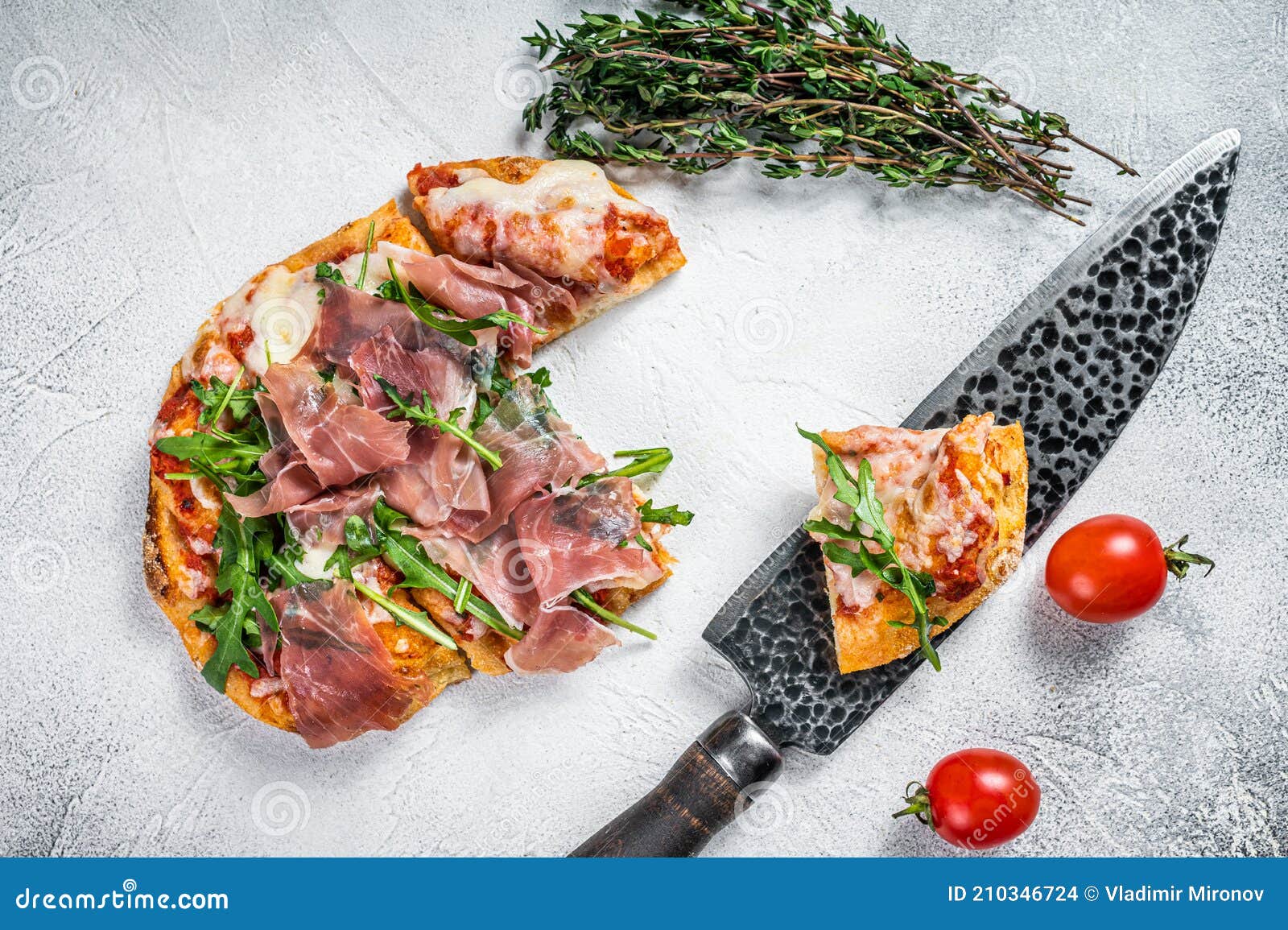 Italian Pizza with Parma Ham, Arugula and Cheeseon a Kitchen Table