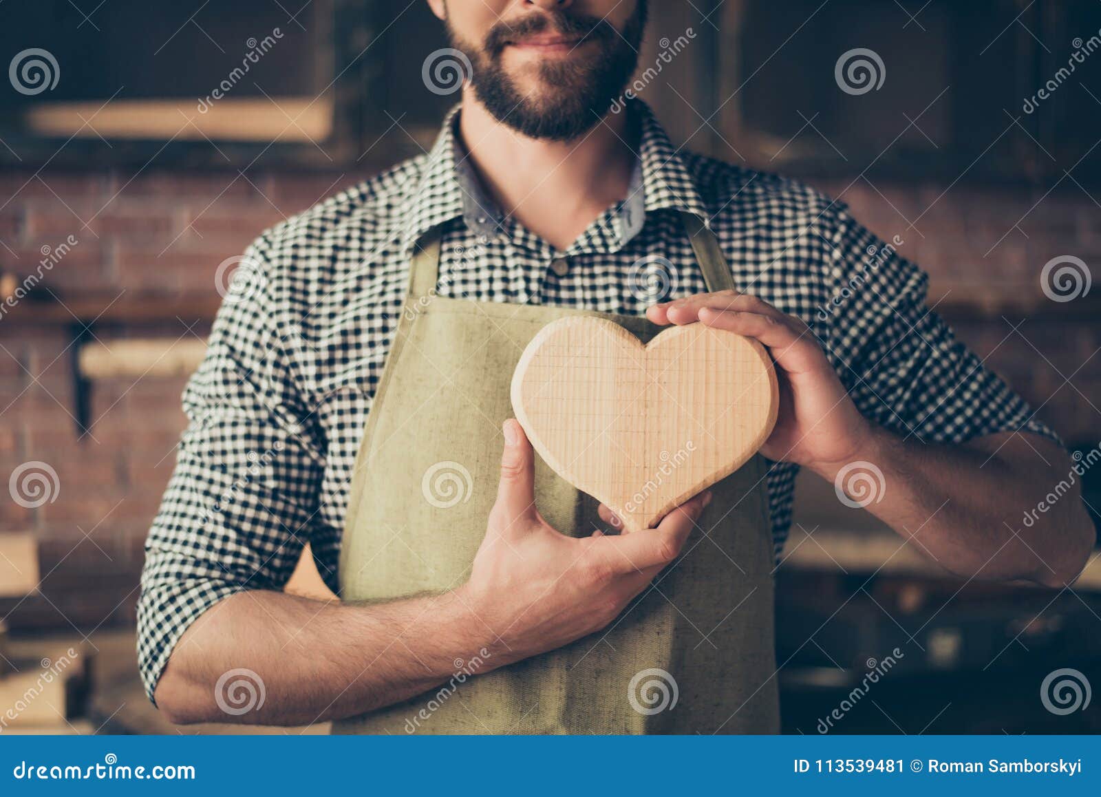 J'aime mon travail ! Photo haute étroite cultivée de c joyeux gai heureux. J'aime mon travail ! Photo haute étroite cultivée de charpentier joyeux gai heureux dans l'amour, il montre un coeur fait de bois