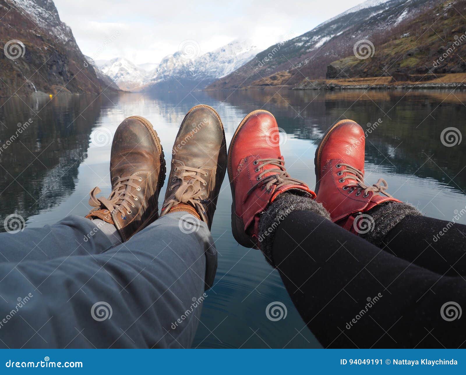 Jambes d'un jeune couple près du lac. Jambes d'un jeune couple dans l'amour près du lac avec le fond de montagne de neige, Flam, Norvège