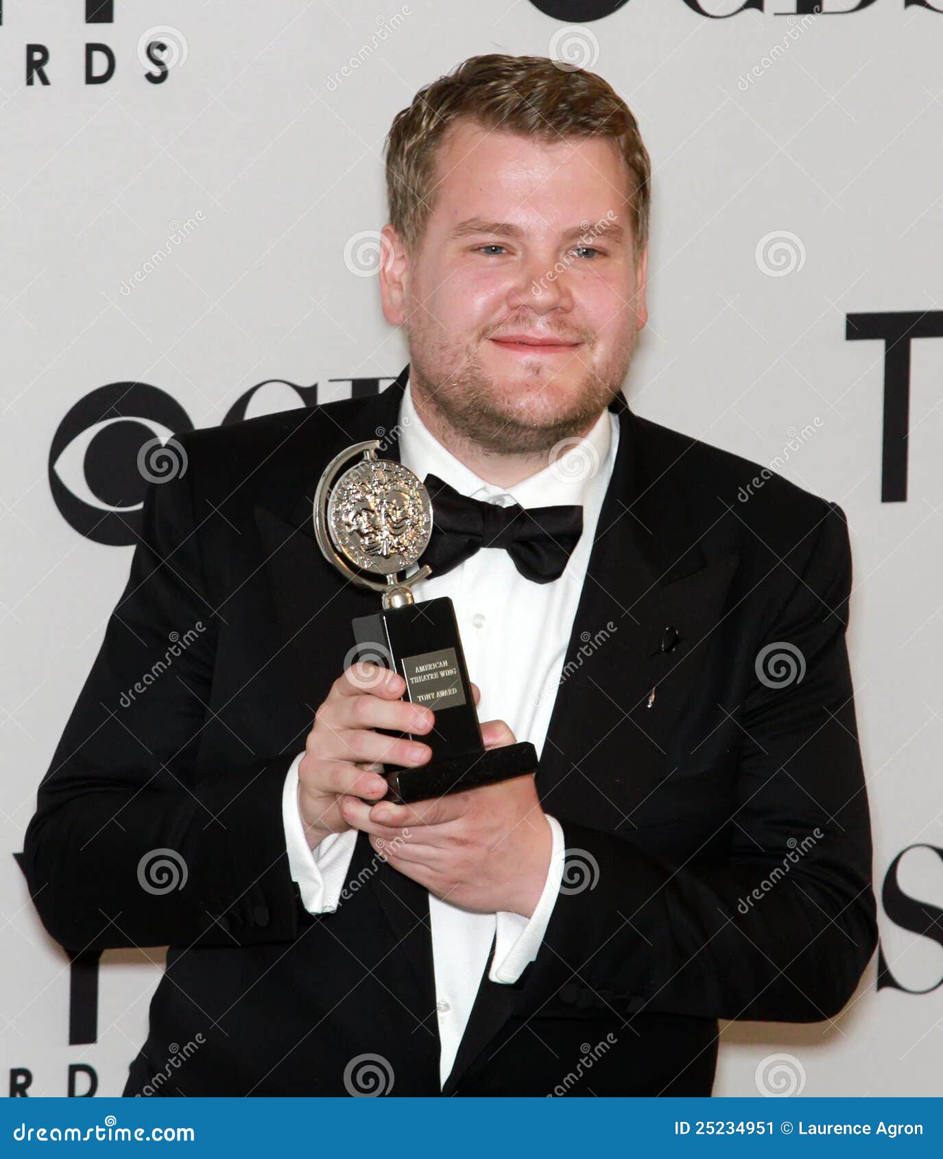 L'attore ed il commediante britannici James Corden solleva la sua statuetta nella stanza di pressa dopo la conquista del suo Tony nella categoria, la migliore prestazione da un attore in un ruolo principale in un gioco per la sua prestazione di bravura del de farce di giro in un uomo, due Guvnors. L'occasione era i sessantesimi Premi Tony annuali a New York City il 10 giugno 2012.