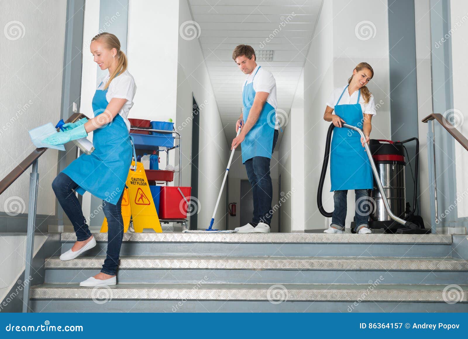 janitors cleaning corridor with cleaning equipments