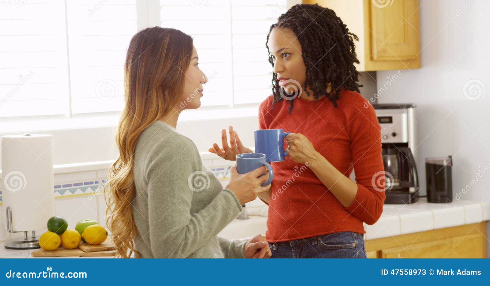 Japanese and Black Friends Drinking Coffee in Kitchen Stock Image