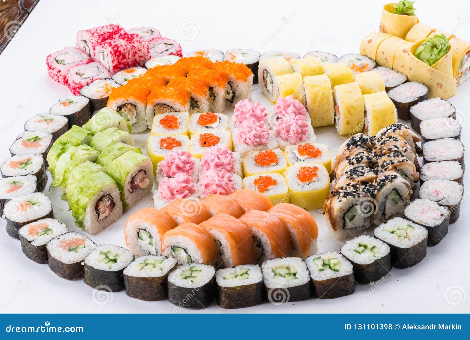 Eating delicious food. Chopsticks taking sushi roll from plate. Seafood  delicatessen salmon gunkan maki on wooden platter. Delicacy gourmet snacks.  Luxury lifestyle, expensive food, restaurant menu Stock Photo