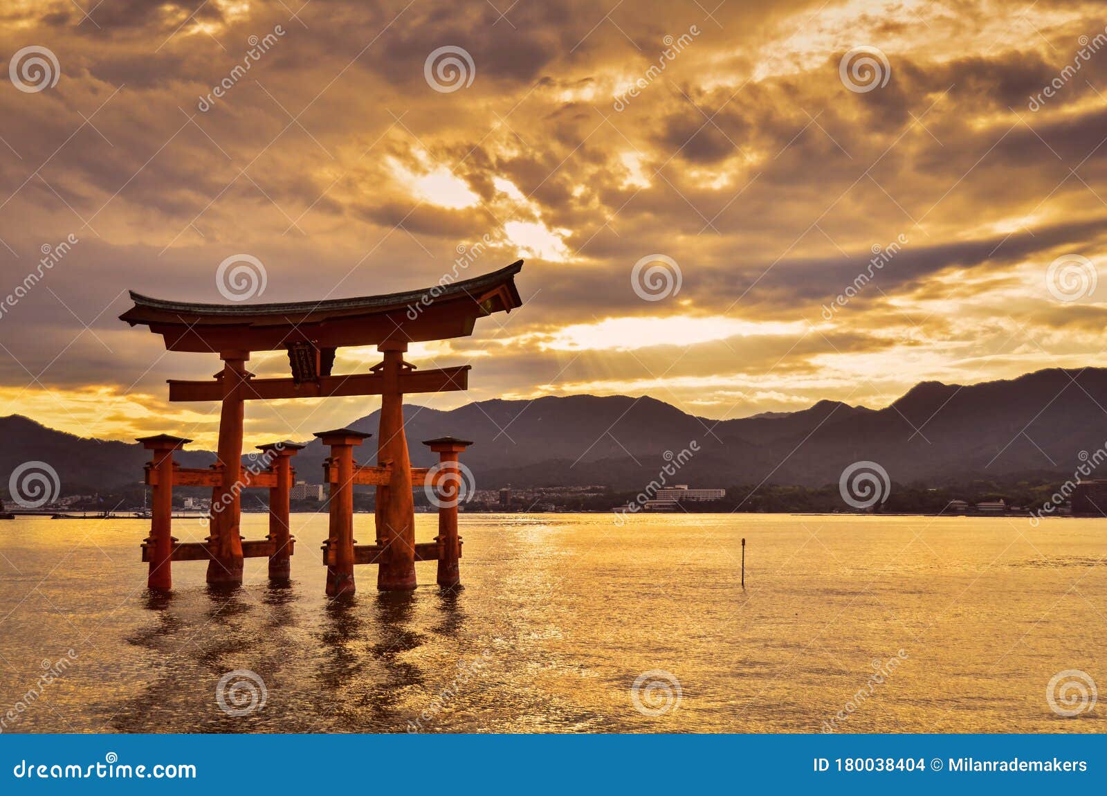 Japanese Torii Gate of Miyajima Standing in the Water with a Beautiful  Dramatic Sunset Over the Mountains in the Background. Stock Photo - Image  of orange, japan: 180038404