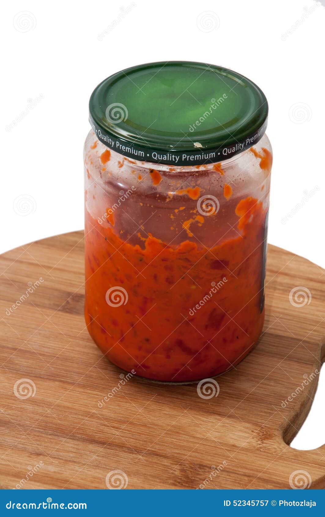 a jar of ajvar on a kitchen wooden board