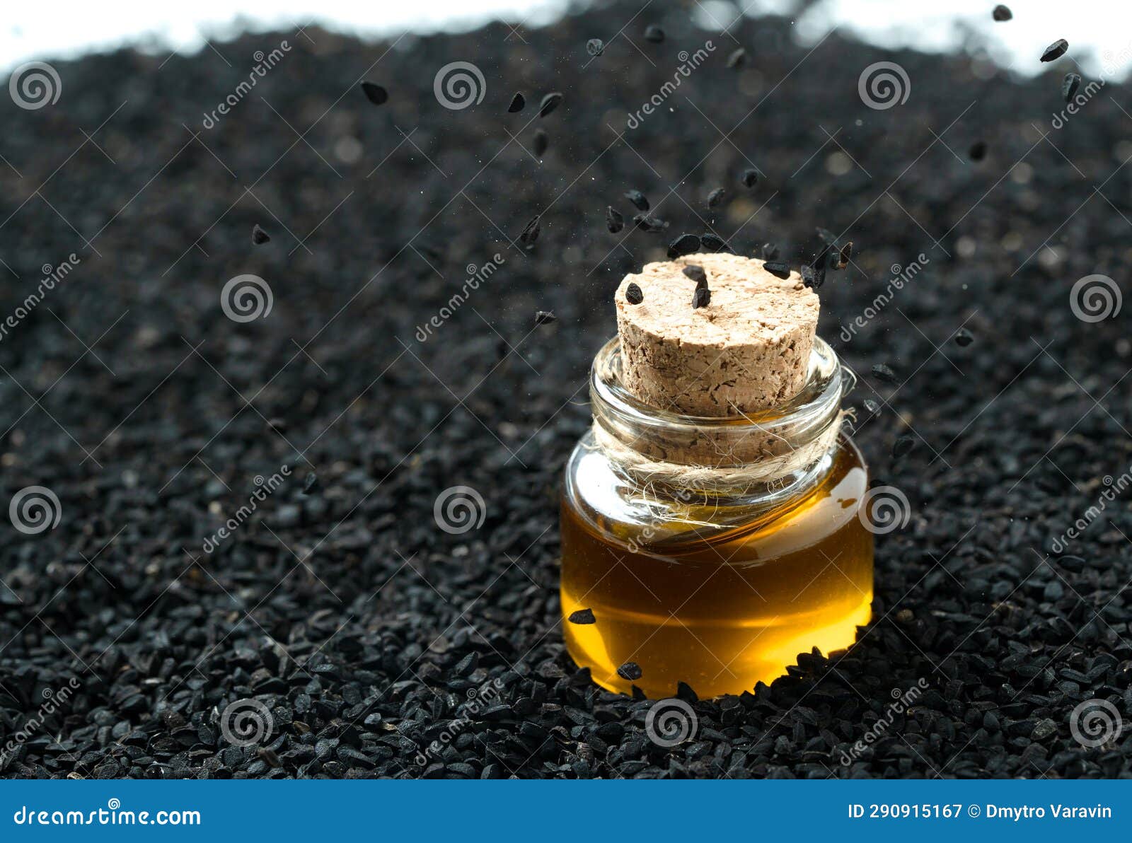 Jar of Black Cumin Oil Standing in Black Cumin Seeds Stock Image