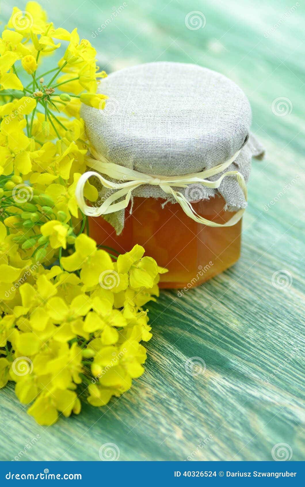 Jar of Delicious Honey in a Jar with Rapeseed Flowers Stock Photo