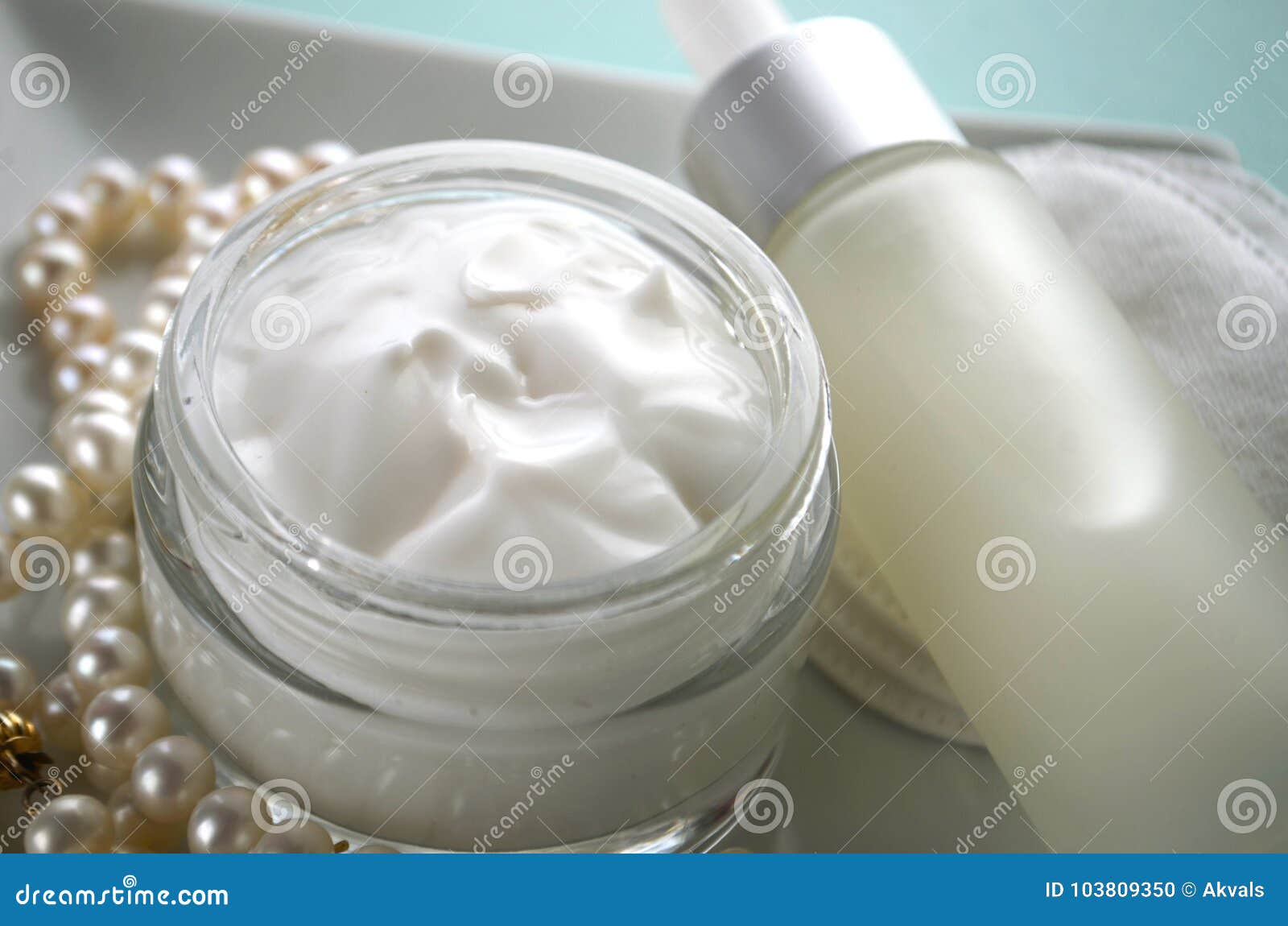 A Jar of Luxury Beauty Face Cream and Serum Bottle with Pearls on Teal ...