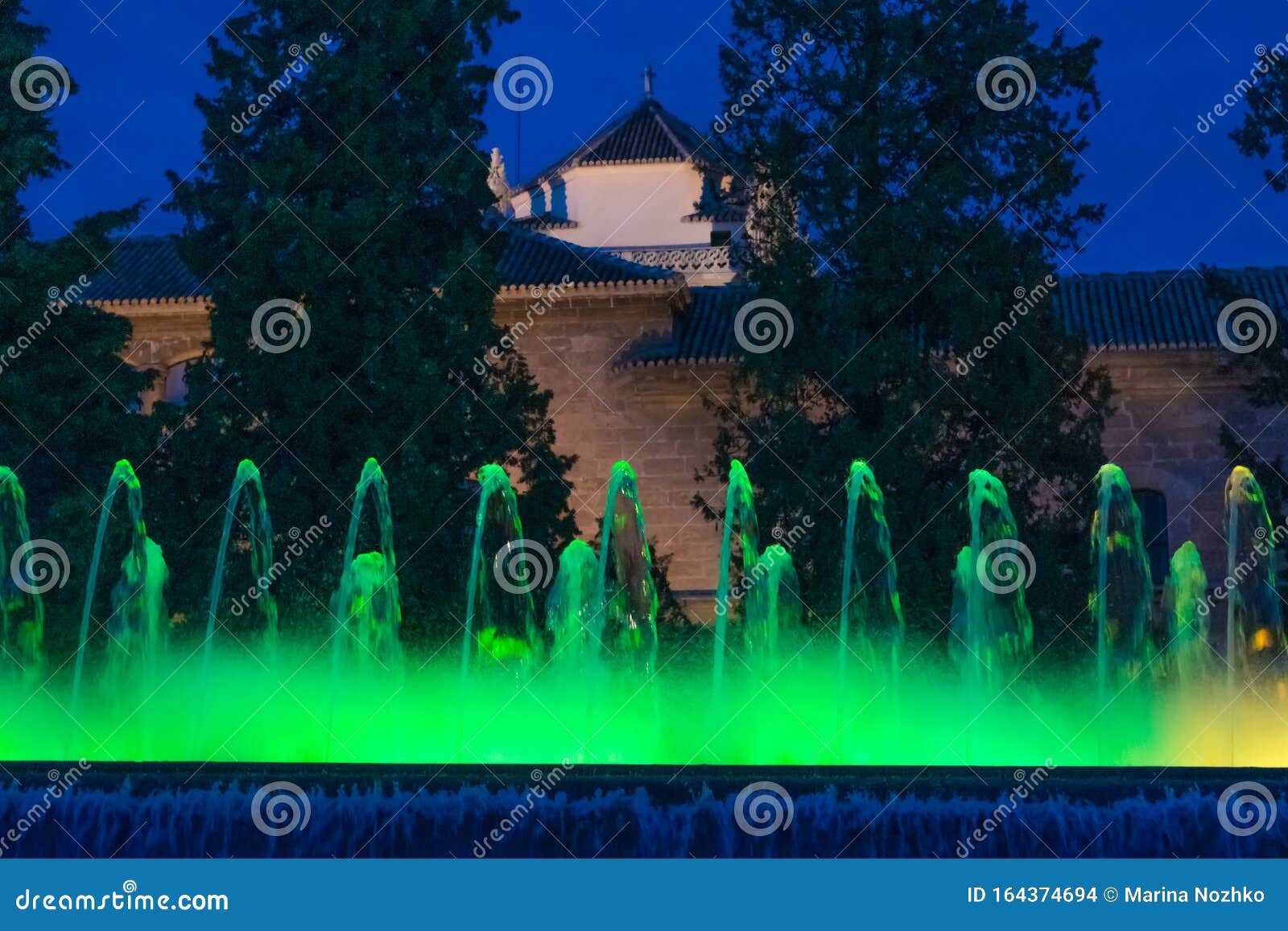 jardines de triunfo and fountain of color green at night, granada, spain