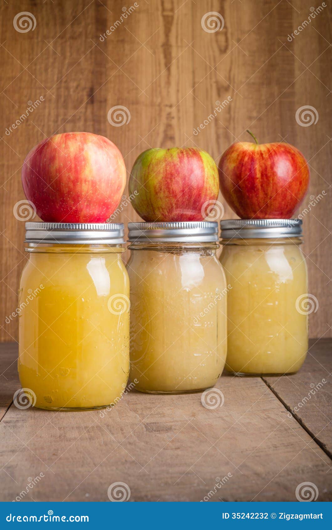 jars of homemade applesauce with apples