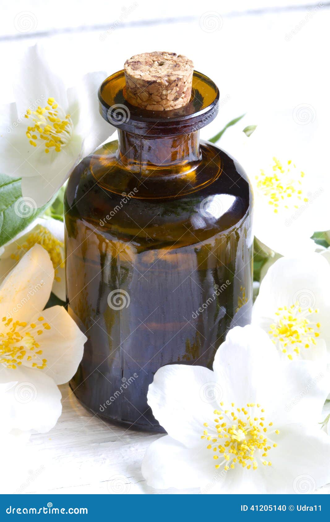 Jasmine Aromatherapy Oil on White Planks with Flowers Stock Photo