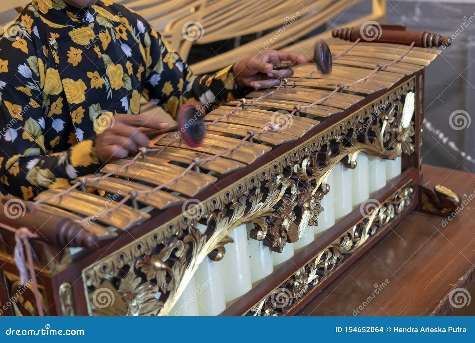 a javanese man playing slenthem, a javanese traditional music instrument