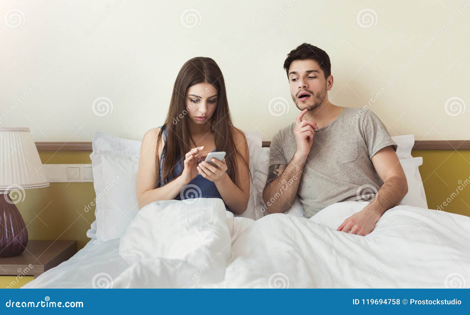 Jealous Husband Watching His Wife Using Mobile Phone Royalty-Fre image picture