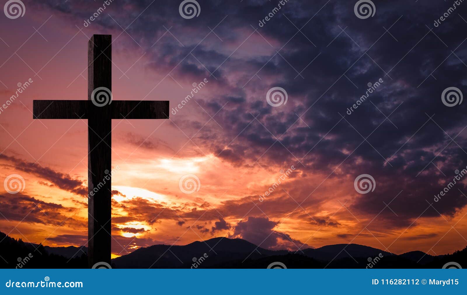 jesus christ cross, wooden crucifix on a heavenly background with dramatic light and clouds and colorful orange sunset