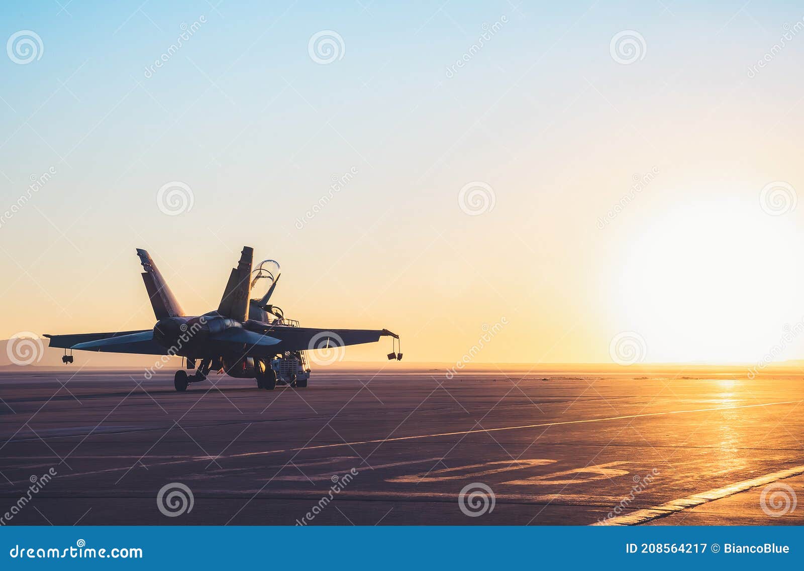 jet fighter on an aircraft carrier deck against beautiful sunset sky .