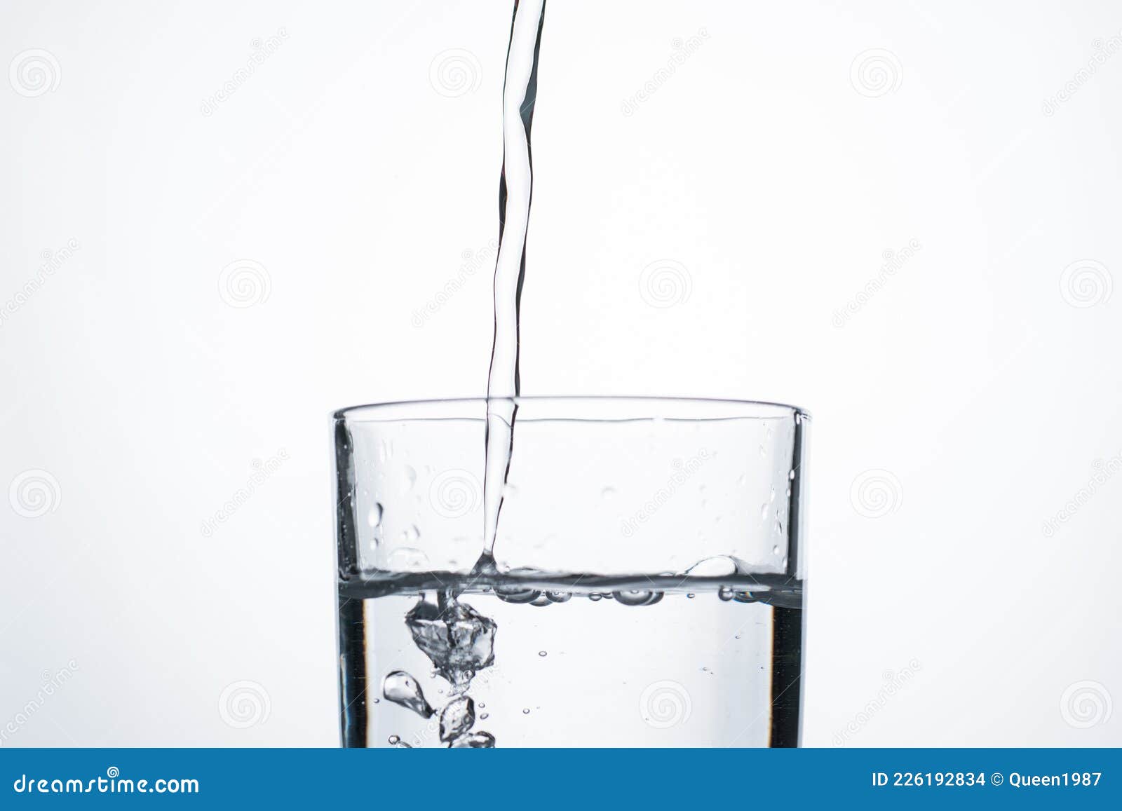 Jet of Water or Alcohol is Pouring into a Glass with Splashes and