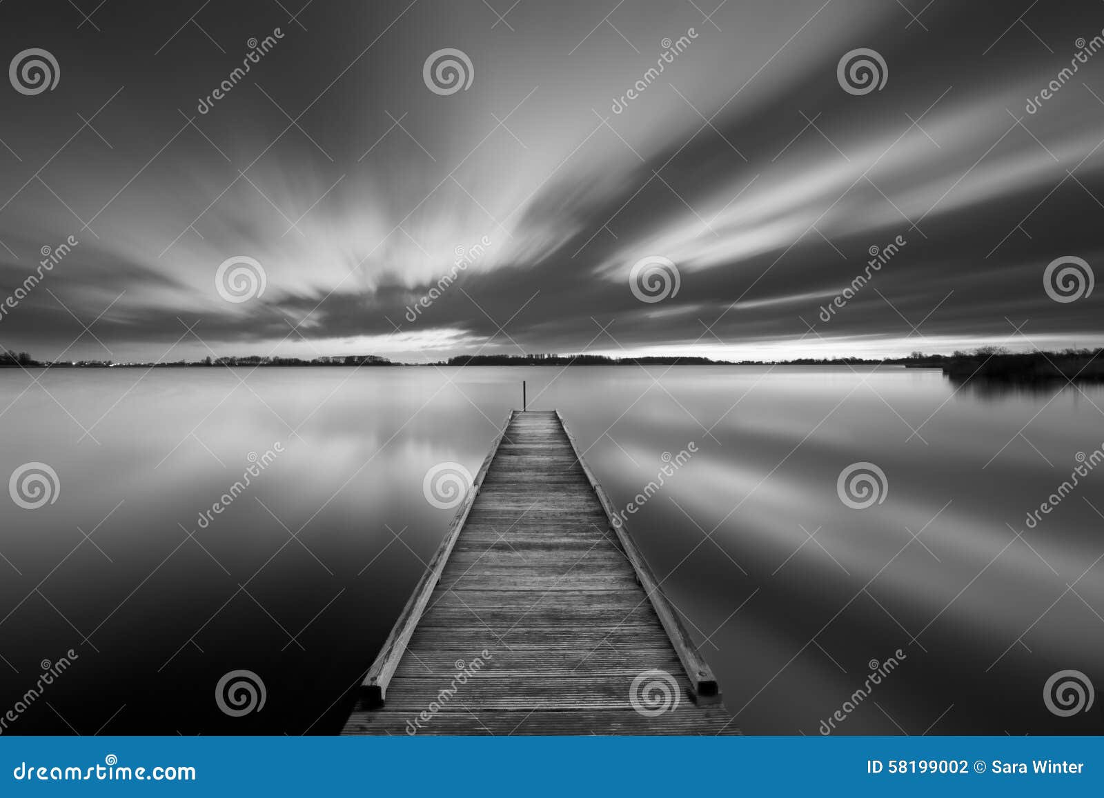 jetty on a lake in black and white