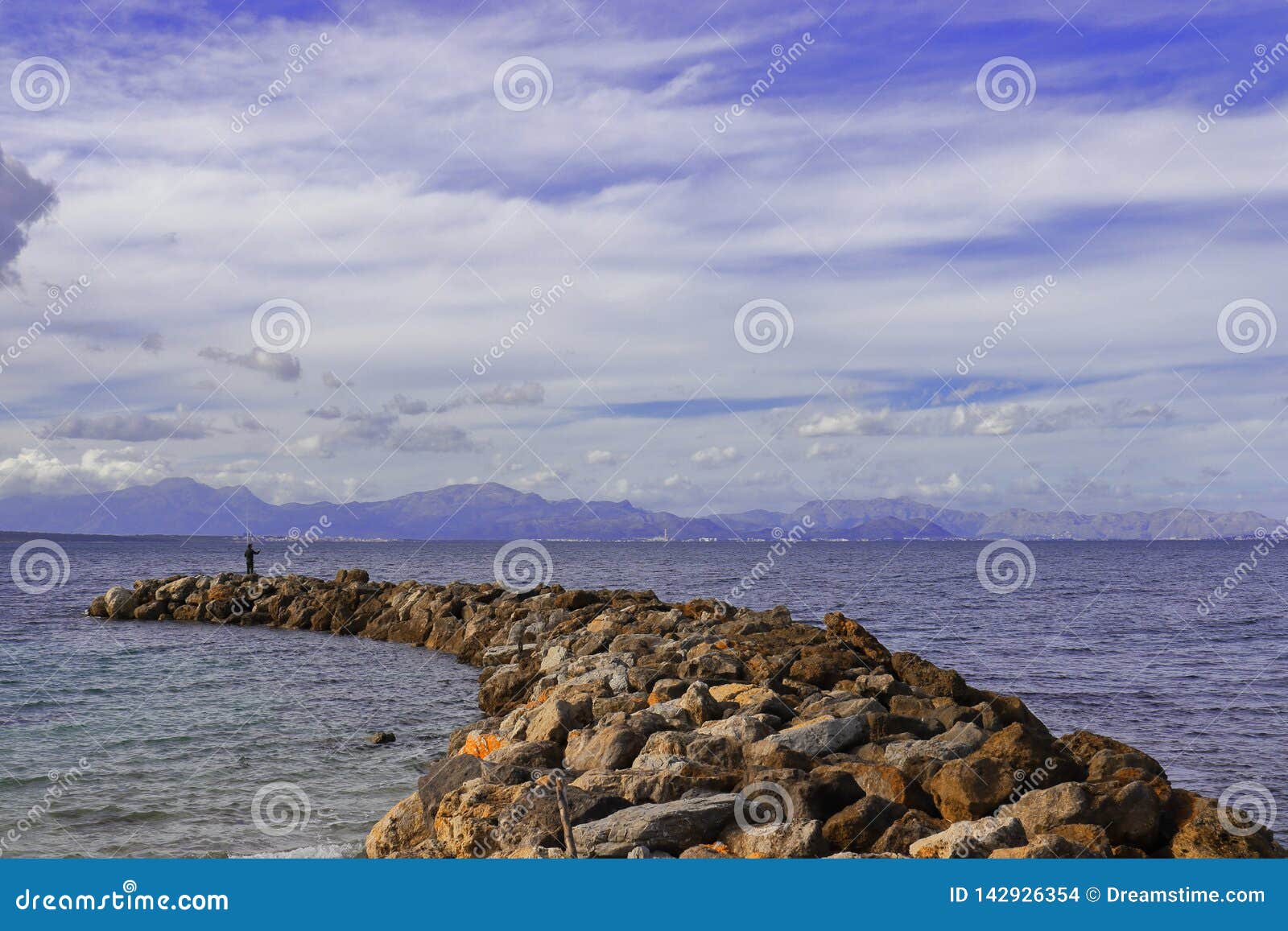 Jetty / Pier of Rocks with Man Fishing and Mountain Backdrop, Mediterranean  Sea, Mallorca, Spain Stock Photo - Image of nature, beautiful: 142926354