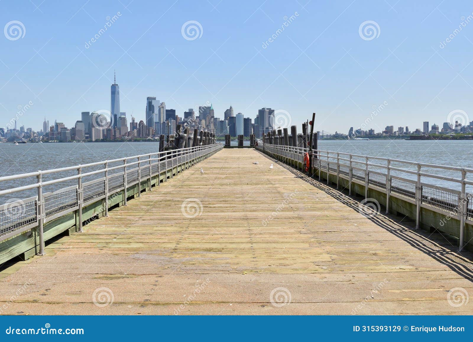 jetty with a view of manhattan skyline from liberty island, ny