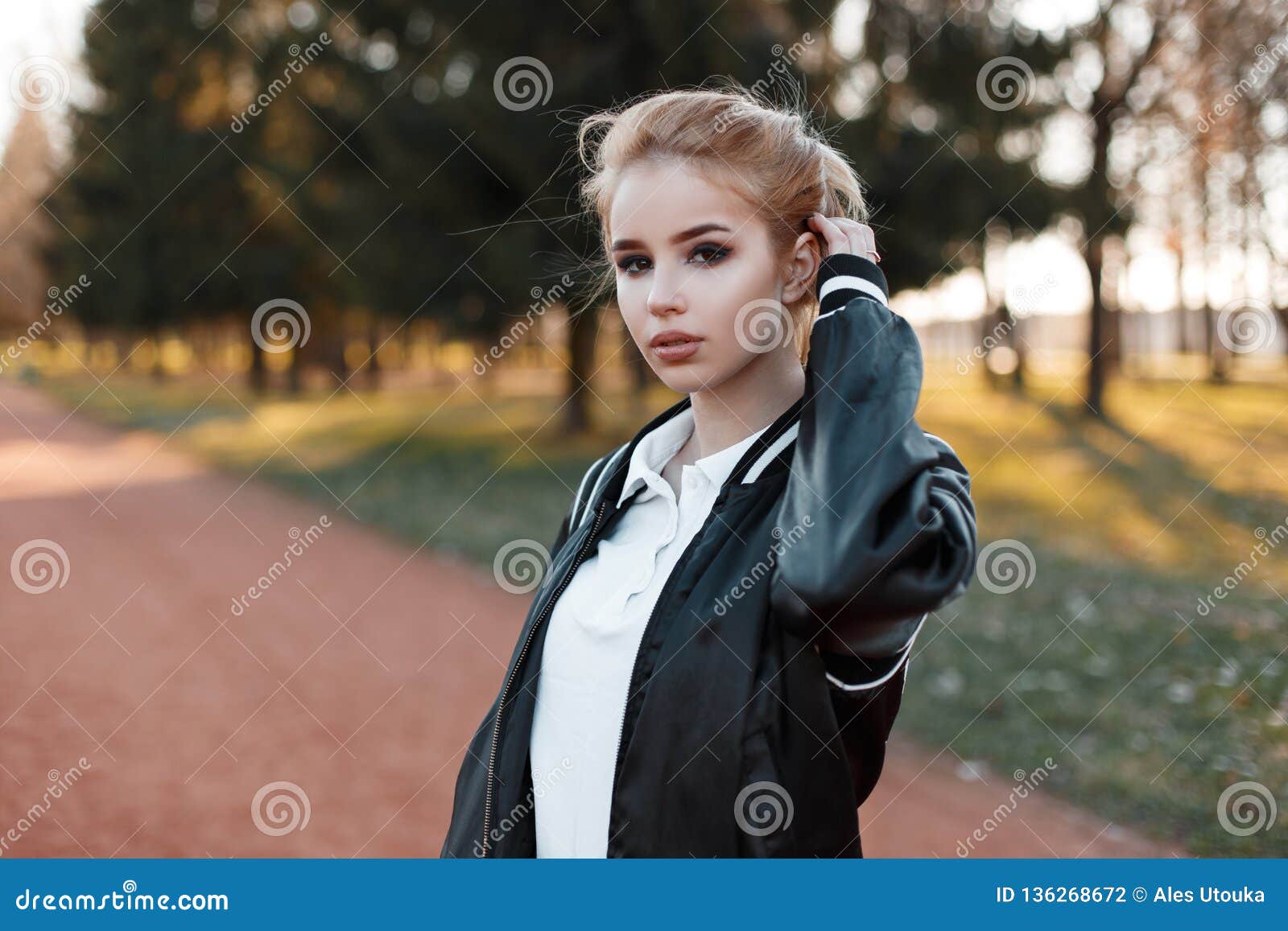 Une Belle Fille Blonde élégante Dans Une Veste Bleue Est Assise