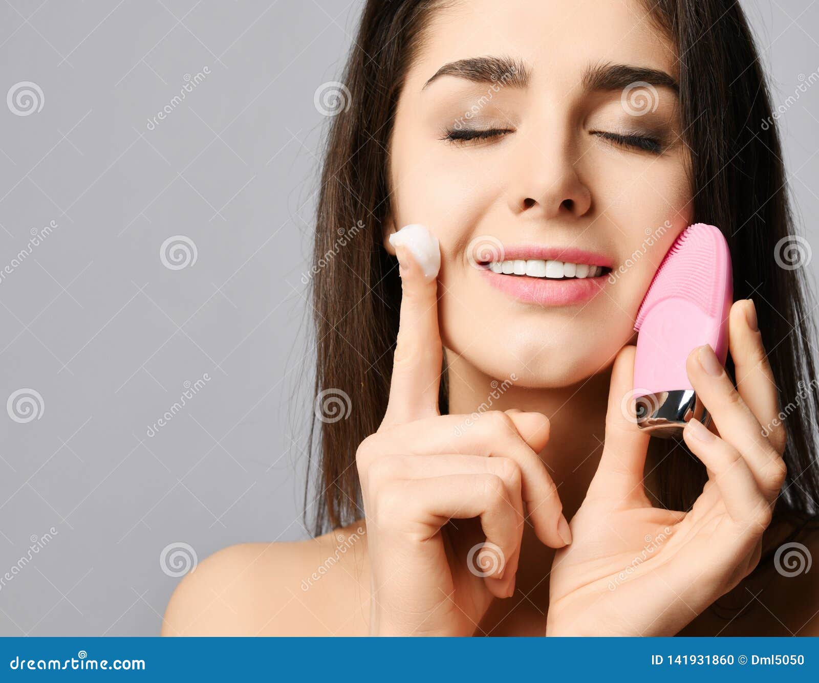 Jeune Femme Utilisant Une Brosse Nettoyante Pour Le Visage Dans La