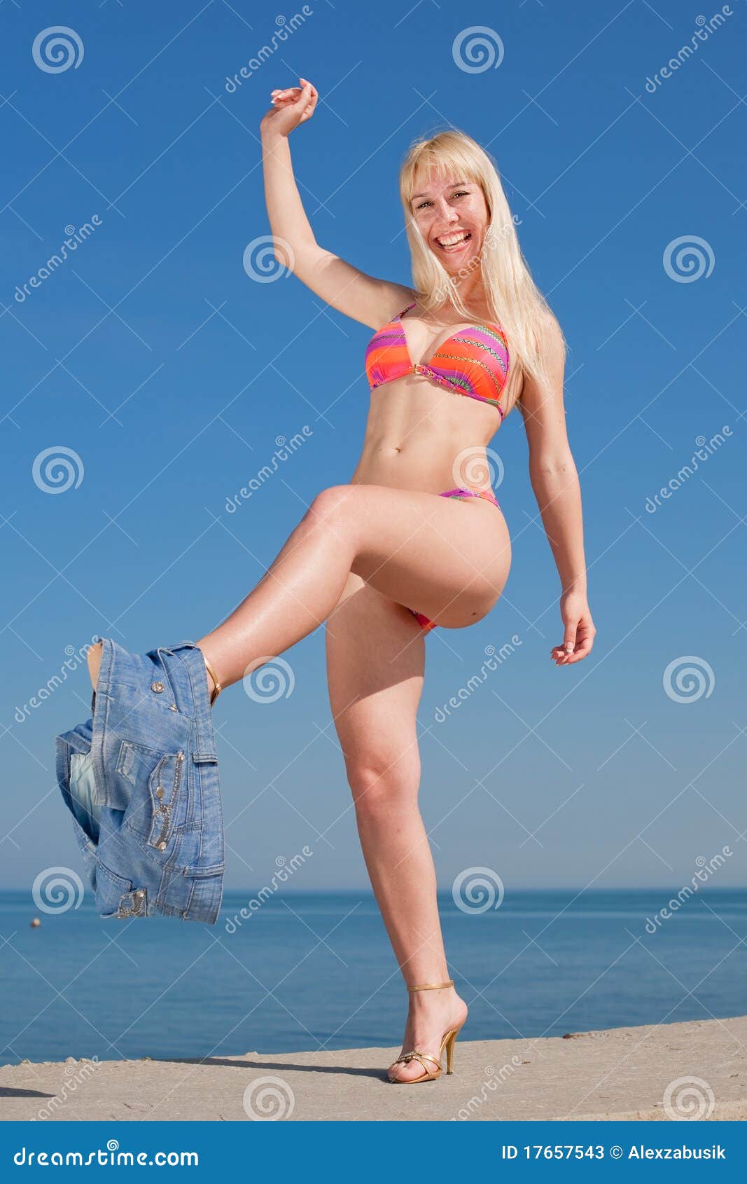 Jeune femme blond dans le bikini à l'extérieur. La femme blonde riante dans le bikini se déshabille à l'extérieur