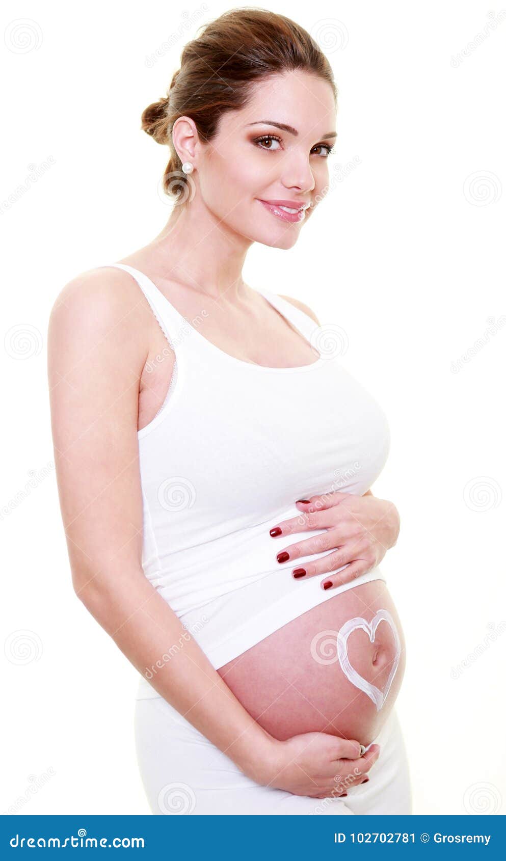 jeune femme brune enceinte avec un coeur sur le ventre.